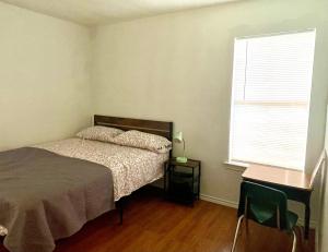 a bedroom with a bed and a desk and a window at Room near downtown Dallas4 in Dallas