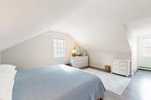 Un dormitorio blanco con una cama y dos ventanas. en Sand Dollar Dreams, en Harwich