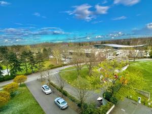 dos autos estacionados en un estacionamiento en un parque en Trip Inn Hotel Frankfurt-Heusenstamm, en Heusenstamm