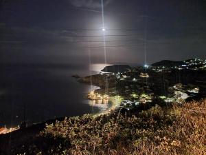 una vista de una ciudad por la noche con la luna en Bellevue Village ''Αdults Only'' en Agia Pelagia