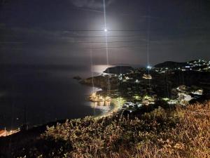 una vista de una ciudad por la noche con la luna en Bellevue Village ''Αdults Only'', en Agia Pelagia