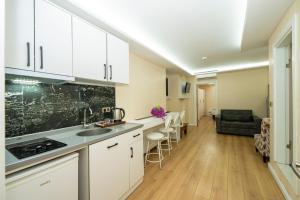 a kitchen with white cabinets and a living room at Luce Suites Taksim in Istanbul