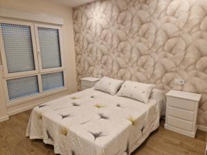 ein Schlafzimmer mit einem Bett und einer Federwand in der Unterkunft Apartaments Mariña B5 in Redondela