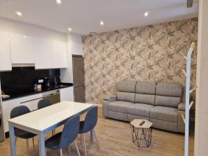 eine Küche und ein Wohnzimmer mit einem Tisch und einem Sofa in der Unterkunft Apartaments Mariña B5 in Redondela