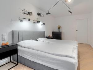 a bedroom with a bed with white sheets and lights at Seaside Retreat Gdańsk - 64m2, Parking, Workspace- by Rentujemy in Gdańsk