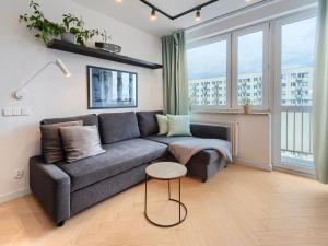 a living room with a couch and some windows at Seaside Retreat Gdańsk - 64m2, Parking, Workspace- by Rentujemy in Gdańsk