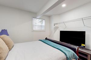 a bedroom with a bed and a flat screen tv at Orange Street Haven in Wilmington
