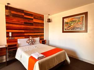 1 dormitorio con 1 cama con pared de madera en Hotel Plaza Central, en Ayacucho
