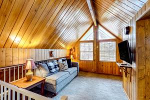 uma sala de estar com um sofá num tecto de madeira em Sleepy Bear em Big Bear City