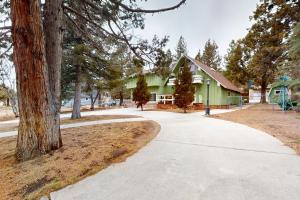uma casa verde com uma árvore e um passeio em Sleepy Bear em Big Bear City