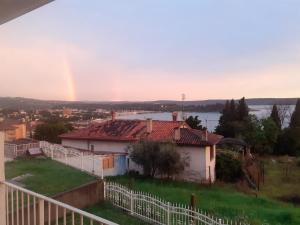 einen Regenbogen über einem Haus mit einem weißen Zaun in der Unterkunft Guest House Vila Luka in Portorož