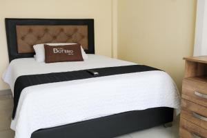 a bedroom with a bed with a black and white comforter at Hotel Casa Botero 301 in Bogotá