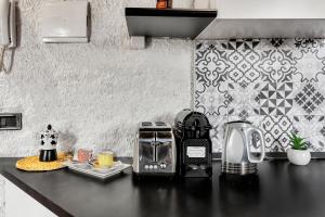 Porta Venezia-Buenos Aires Chalet House in Shopping District Free Wifi Netflix في ميلانو: طاولة مطبخ مع محمصة وآلة صنع قهوة عليها