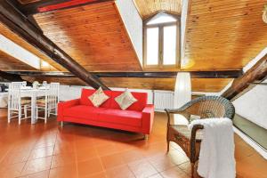divano rosso in camera con soffitti in legno di Porta Venezia-Buenos Aires Chalet House in Shopping District Free Wifi Netflix a Milano