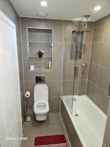 a bathroom with a shower and a toilet and a tub at LONDON SLEEPHOUSE in London