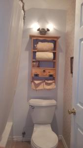 a bathroom with a toilet and a bunch of towels at Canyon Country Inn in Williams