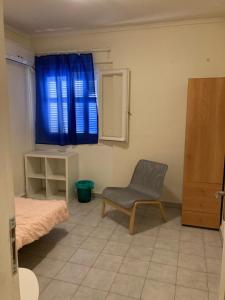アテネにあるArtemidos Apartmentのベッドルーム(椅子、青い窓付)