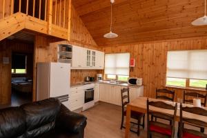 eine Küche und ein Esszimmer mit einem Tisch in einer Hütte in der Unterkunft Gladheimar Cottages in Blönduós