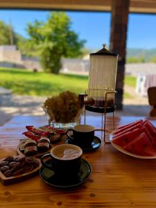 a table with cups of coffee and cookies on it at Loly Luxury Guest House in Dilijan