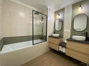 ein Badezimmer mit Badewanne, Waschbecken und Badewanne Tubermottermott in der Unterkunft La Serrisienne 8 - Val d'Europe - Disneyland Paris - 8 à 10 Personnes in Serris