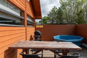 a wooden table and chairs on a patio with a tub at Gladheimar Cottages in Blönduós +120 photos