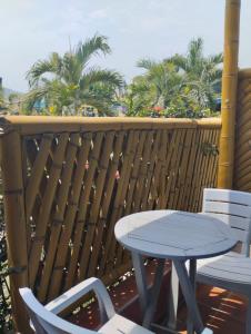 uma mesa e cadeiras numa varanda com palmeiras em La Rivera Playa Palomino em Palomino