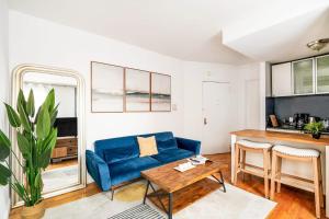 uma sala de estar com um sofá azul e uma mesa em 139-3E west village 1BR best value em Nova Iorque