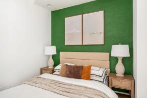 - une chambre avec des murs verts et un lit avec deux lampes dans l'établissement 139-3E west village 1BR best value, à New York
