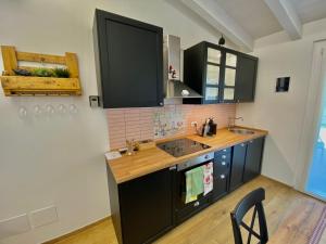 a kitchen with black cabinets and a sink at Il Casaletto - Guest House in Terni