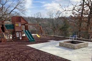 einen Spielplatz mit Rutsche und Spielstruktur in der Unterkunft Harper Valley 01 in Kimberling City