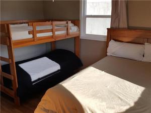 a small room with two bunk beds and a window at Beach House Sleep 20 with VIP pkg, Bachelor Parties Welcomed in Lake Ozark