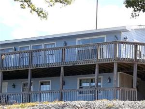 a large blue building with a wooden balcony at Beach House Sleep 20 with VIP pkg, Bachelor Parties Welcomed in Lake Ozark