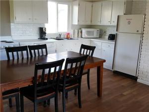 a kitchen with a table and chairs and a refrigerator at Beach House Sleep 20 with VIP pkg, Bachelor Parties Welcomed in Lake Ozark