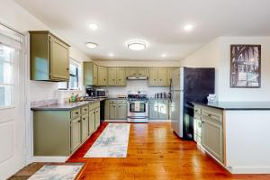 uma cozinha com armários verdes e electrodomésticos de aço inoxidável em Lakeside Life em Rogers