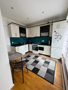 a kitchen with white cabinets and a checkered floor at Urban Haven Sarajevo in Sarajevo