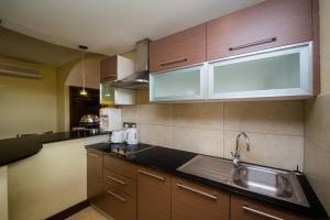 a kitchen with wooden cabinets and a sink at Taarifa Suites by Dunhill Serviced Apartments in Nairobi