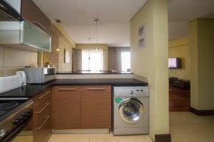 a kitchen with a washer and a washing machine at Taarifa Suites by Dunhill Serviced Apartments in Nairobi