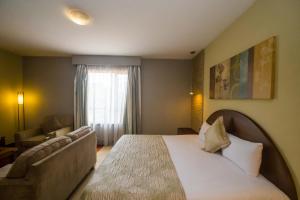 a hotel room with a bed and a couch at Taarifa Suites by Dunhill Serviced Apartments in Nairobi