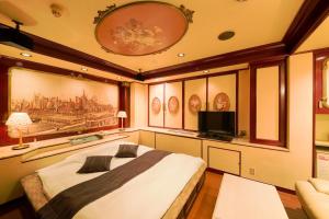 a bedroom with a large bed and a flat screen tv at Hotel Public Jam in Osaka