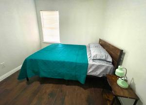 a bedroom with a bed with a blue blanket on it at Private room pleasant grove in Dallas