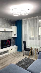 a living room with a table and a tv at Bucharest luxury apartments Bragadiru in Bragadiru
