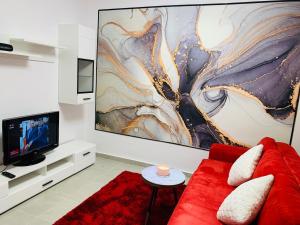 a living room with a red couch and a tv at Bucharest luxury apartments Bragadiru in Bragadiru +32 photos