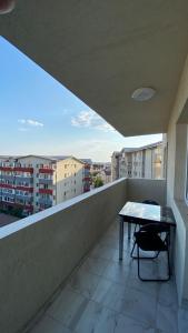 a balcony with a table and a view of a city at Bucharest luxury apartments Bragadiru in Bragadiru