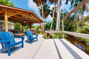 une terrasse avec deux chaises bleues et un pavillon dans l'établissement Riverside Cottages, à Bonita Springs