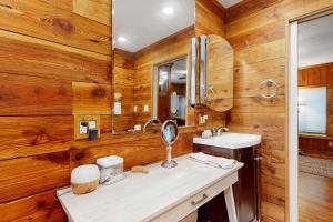 une salle de bain avec des murs en bois, un lavabo et un miroir dans l'établissement Riverside Cottages, à Bonita Springs 41 autres photos
