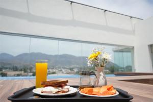 特皮克的住宿－hotel vista valle，盘子,盘子上放着两盘食物和一杯橙汁