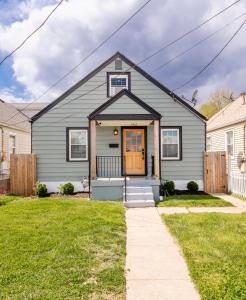 una casa gris con puerta naranja en Urban Cottage-Bourbon Trail, Expo, YUM, Derby! en Louisville