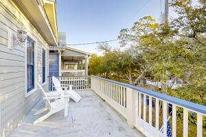 une terrasse couverte avec 2 chaises blanches sur une maison dans l'établissement Heart of Paradise, à Jacksonville
