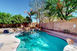 a swimming pool in a backyard with a brick wall at Desert Dreamland Villa in Peoria