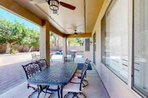 a patio with a table and chairs on a porch at Desert Dreamland Villa in Peoria